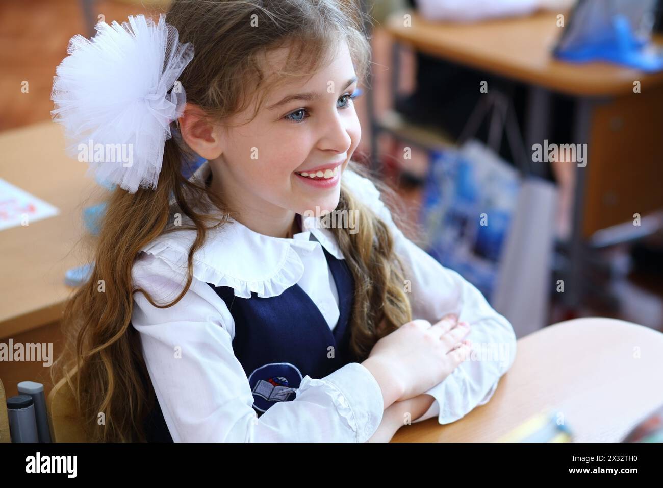 Happy schoolgirl sits at a desk in the classroom Stock Photo - Alamy