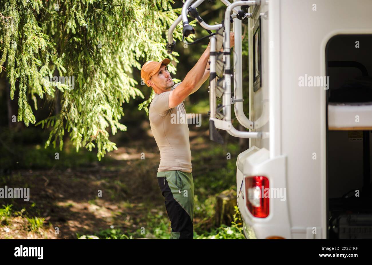 Caucasian Camper Van RV Owner in His 40s Preparing a Bike Rack. Recreational Vehicles Theme. Stock Photo