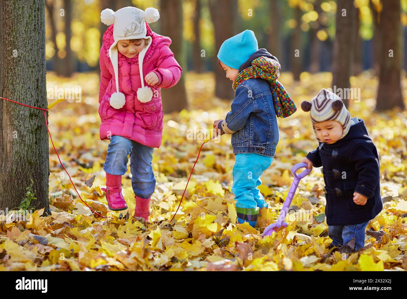 Girl jumps over rope which is twisted by the boy, another one little ...