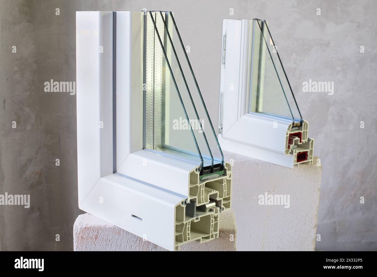 Two sample of PVC windows stands on a concrete block on a concrete wall ...