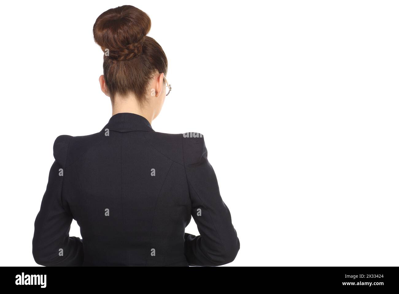 Girl with a chignon in a black suit standing with his back Stock Photo