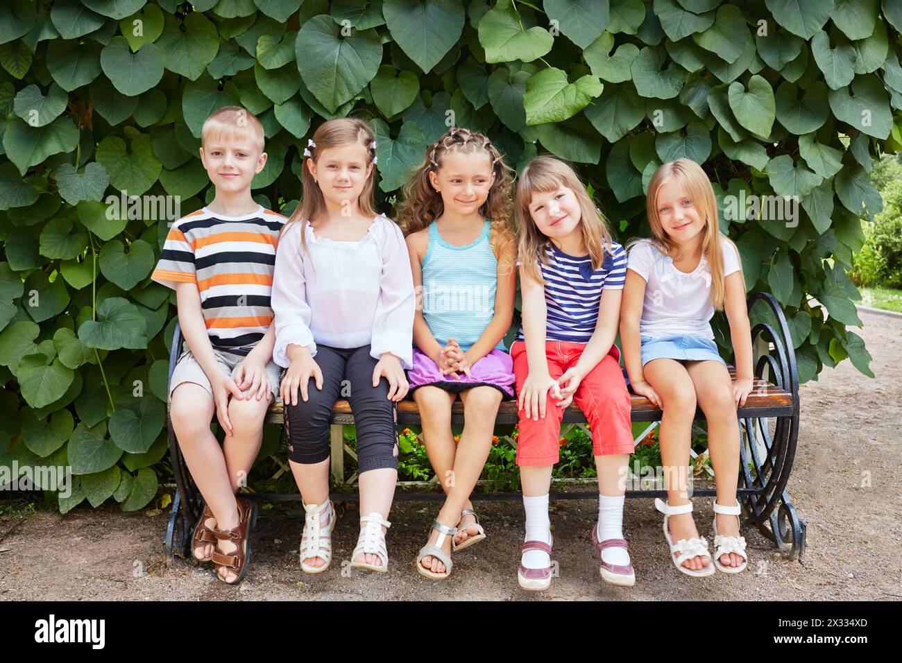 Five children friends sit on bench in summer park Stock Photo - Alamy