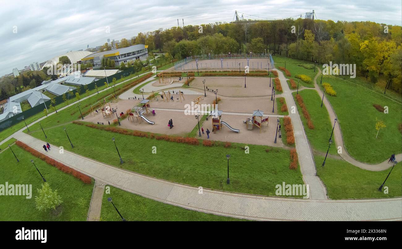 Children with parents are playing on the playground near the park, view from unmanned quadrocopter. Stock Photo