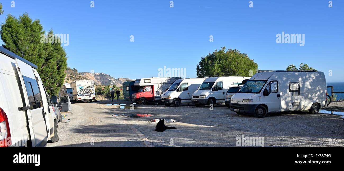 Alternative living in camper vans and cars parked along beachside lane in the Spanish Costa del Sol Stock Photo