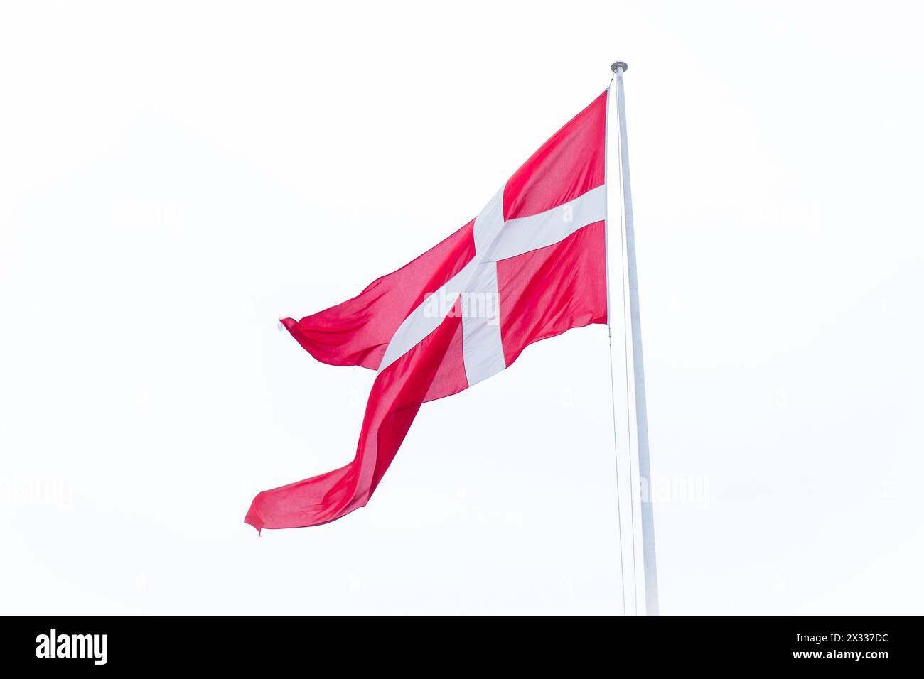 Flag of Denmark on white cloudy sky background. Stock Photo