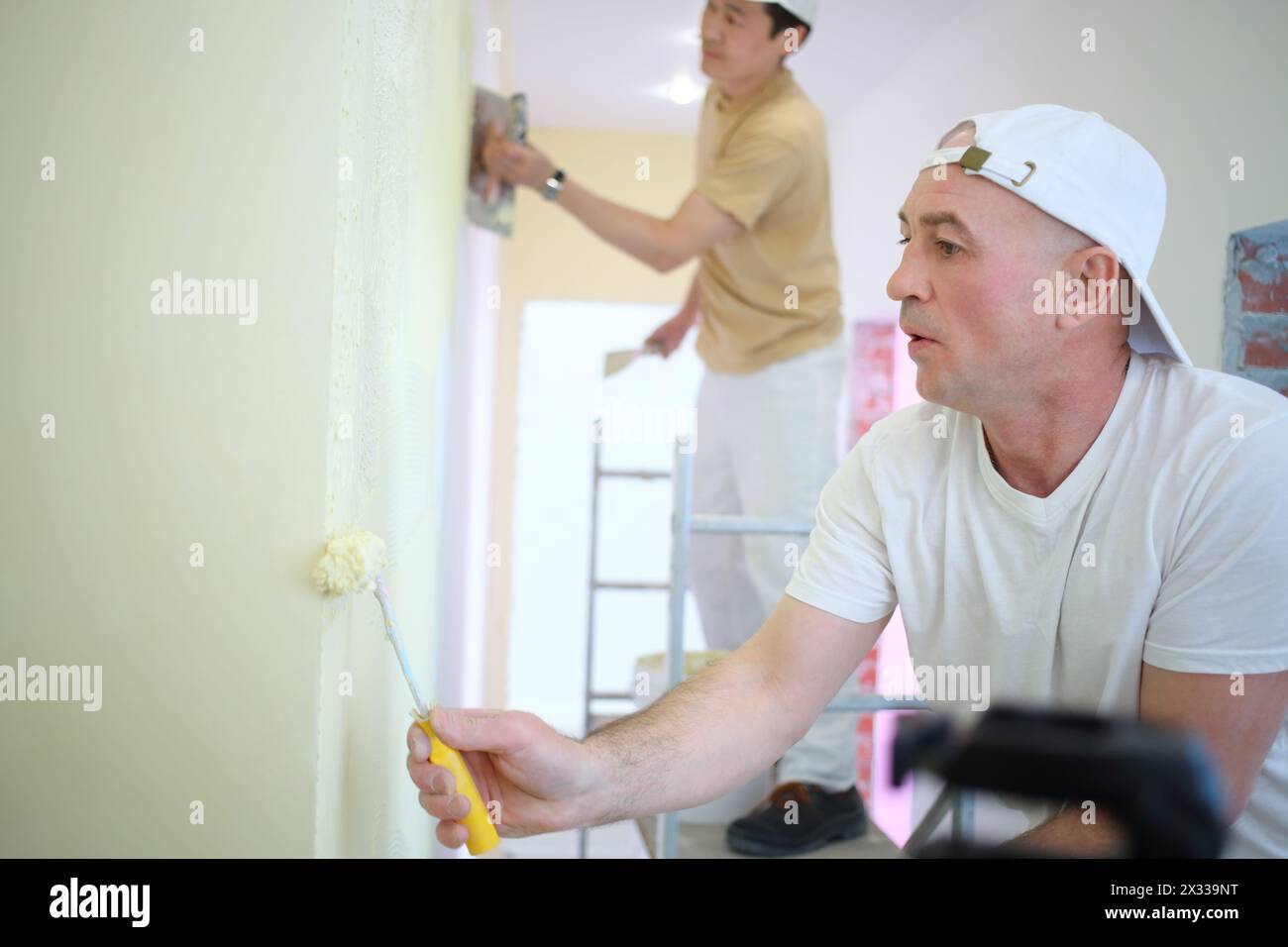 Two builders making finish in the apartment Stock Photo