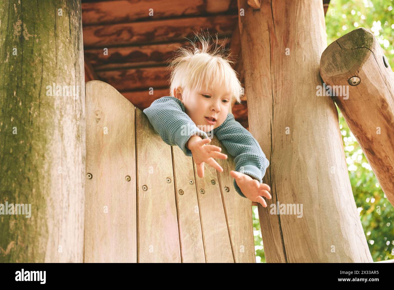 Outdoor portrait of adorable 4 - 5 year old little boy playing on playground Stock Photo