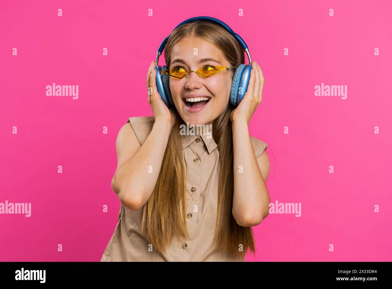 Happy woman in headphones listening music and dancing disco fooling ...