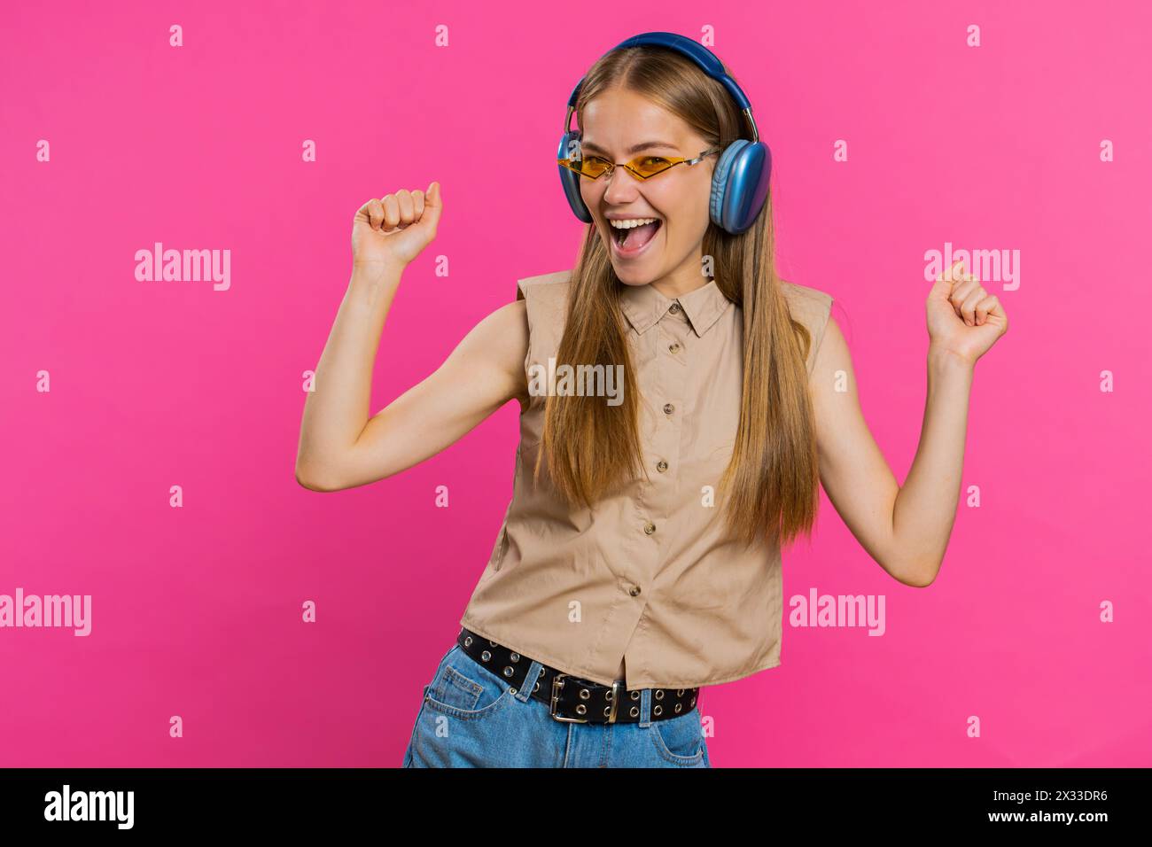 Happy woman in headphones listening music and dancing disco fooling ...