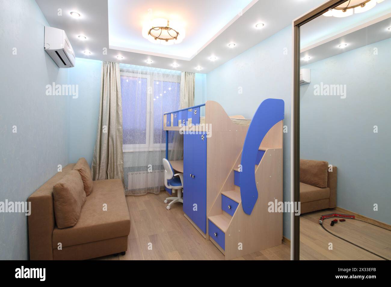 Interior room with blue walls for boy with a loft bed, sofa and sliding door wardrobe Stock Photo
