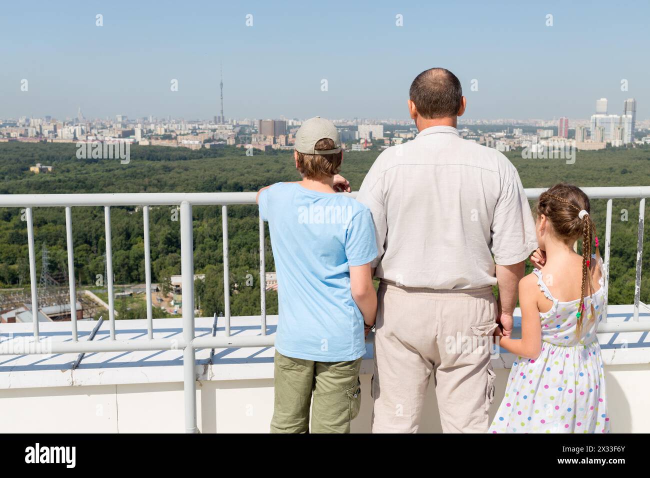 Grandfather with grandchildren admire the city view from the roof Stock Photo