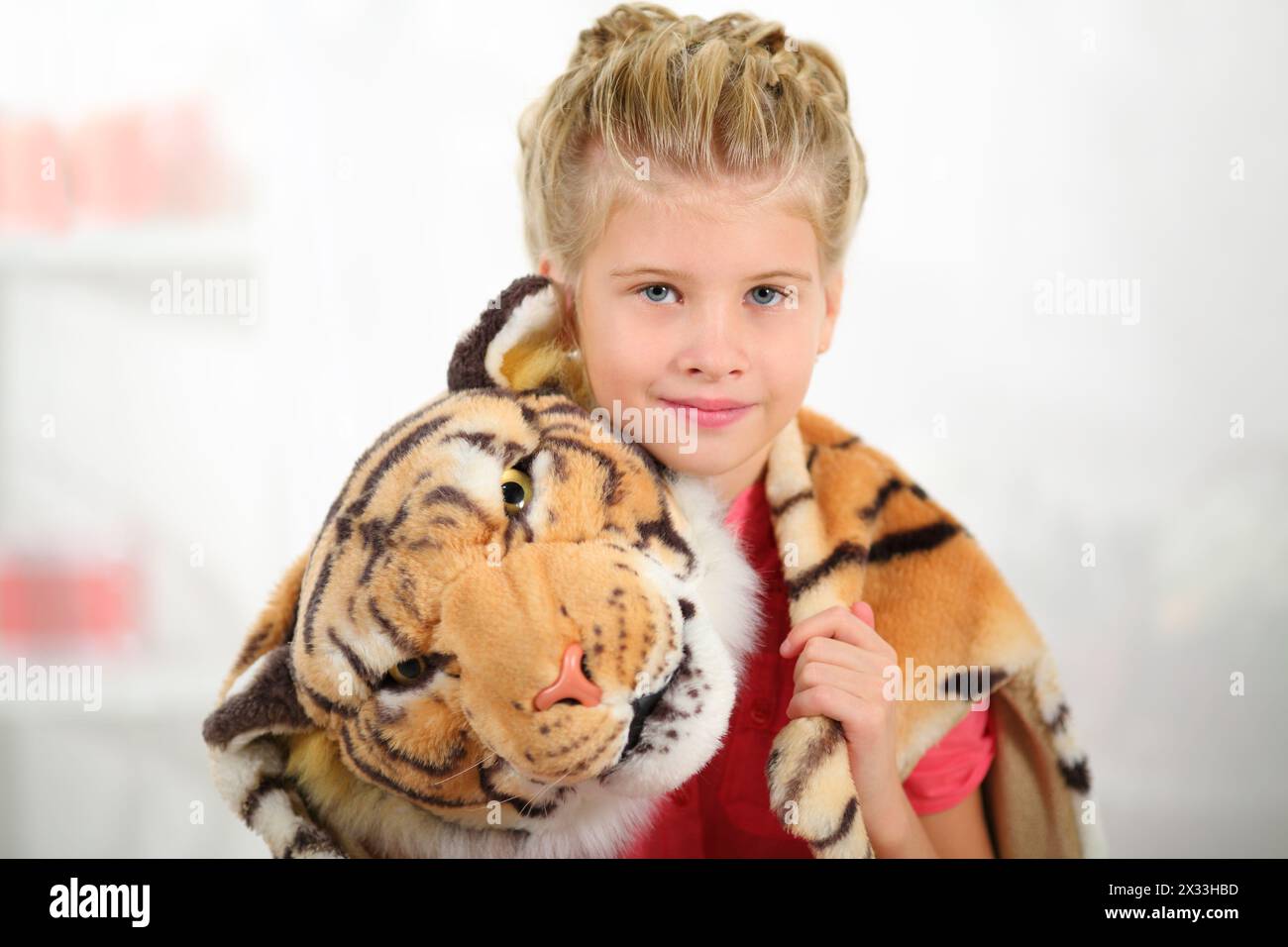 Portrait of a little girl with a tiger skin on her shoulders Stock Photo