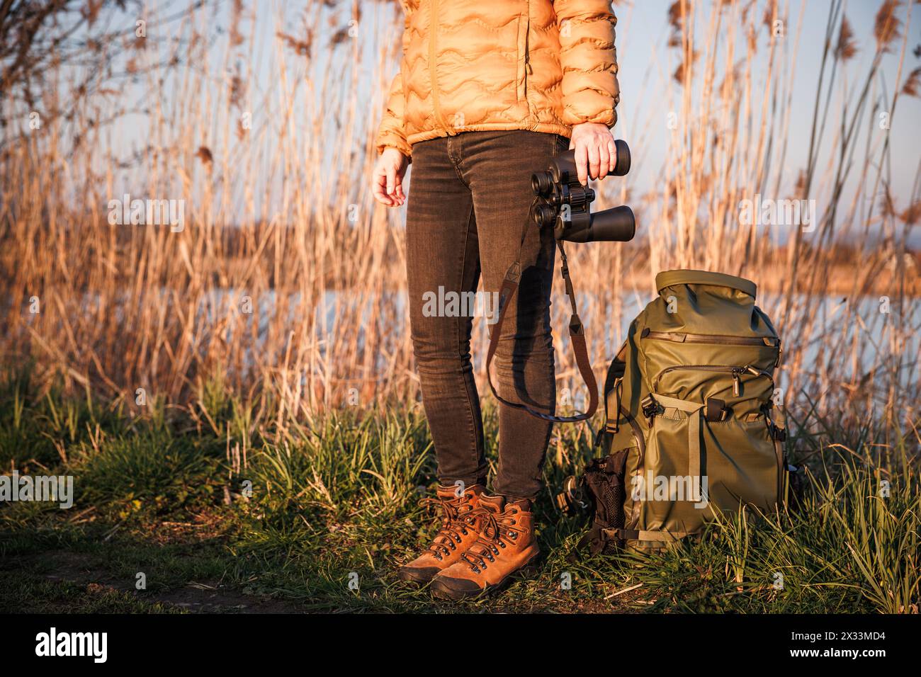 Bird watching at lake. Ornithologist with binoculars and backpack ...