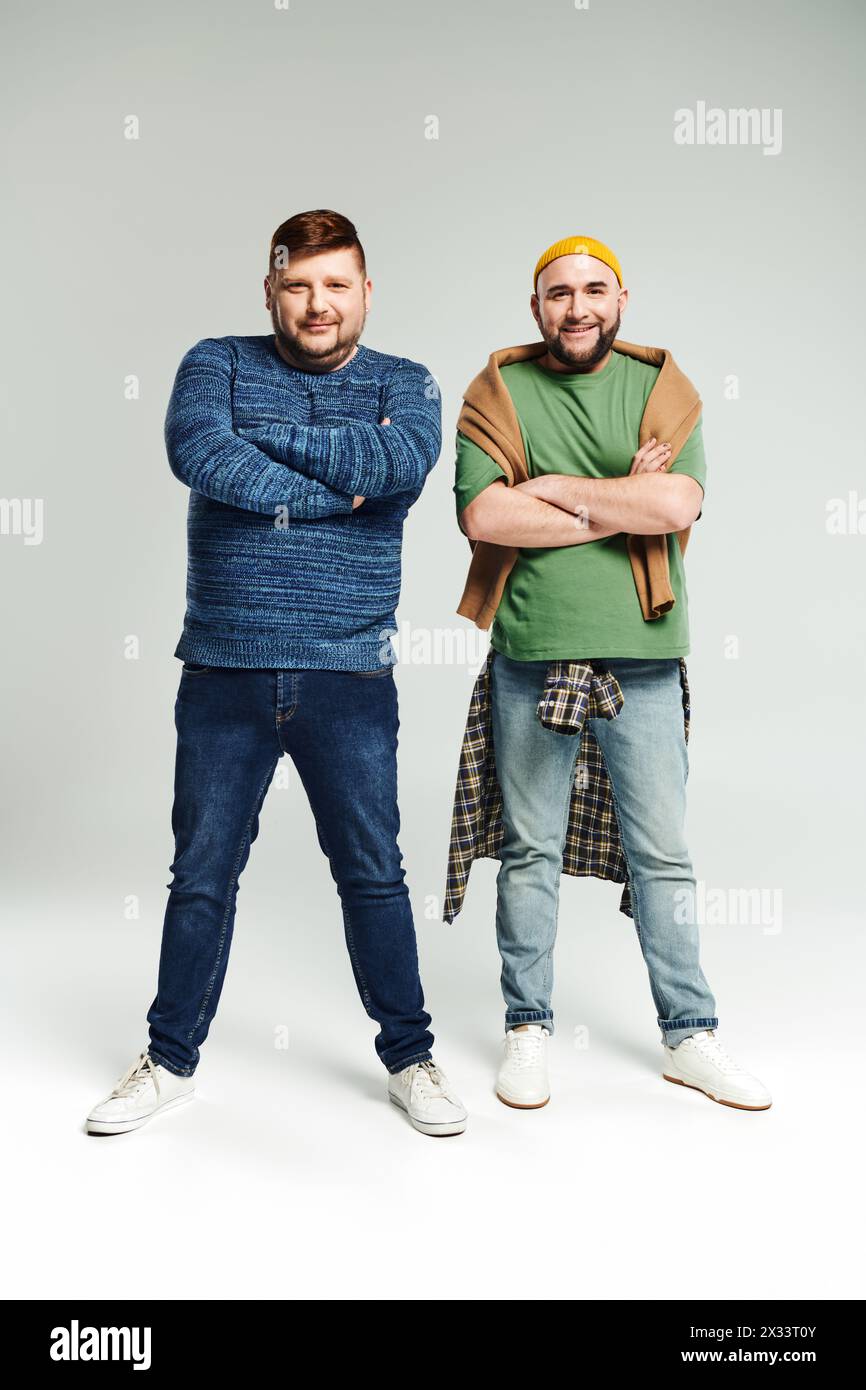 Two men with crossed arms stand confidently next to each other. Stock Photo