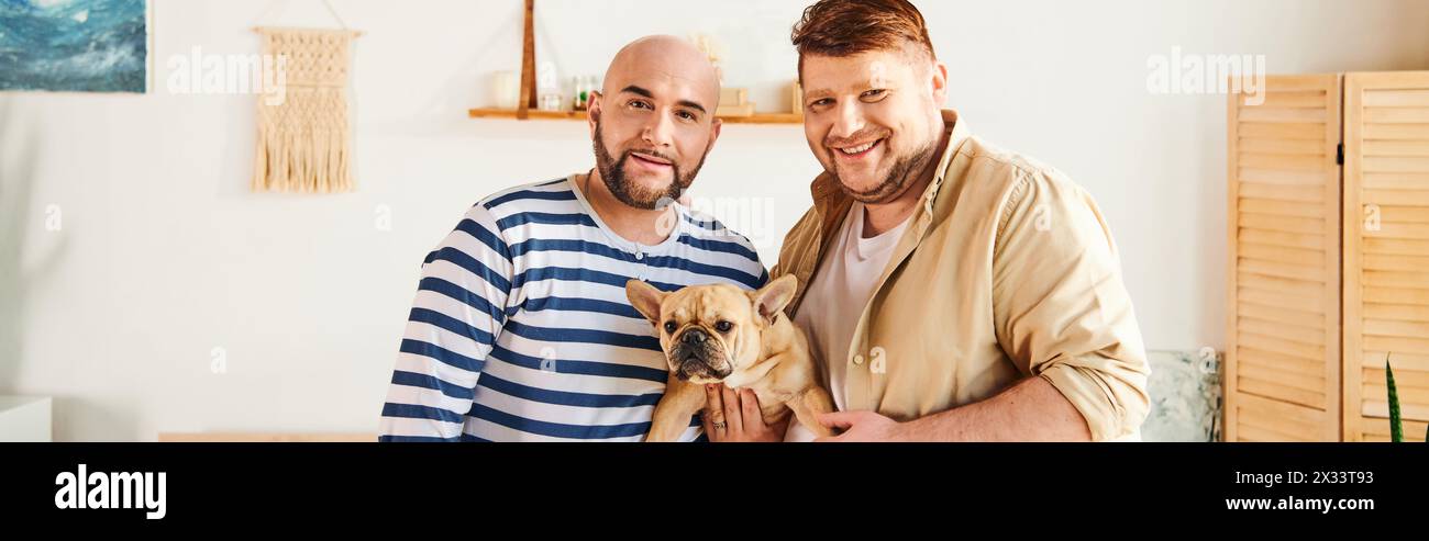 Gay couple serenely holding a French Bulldog at home. Stock Photo