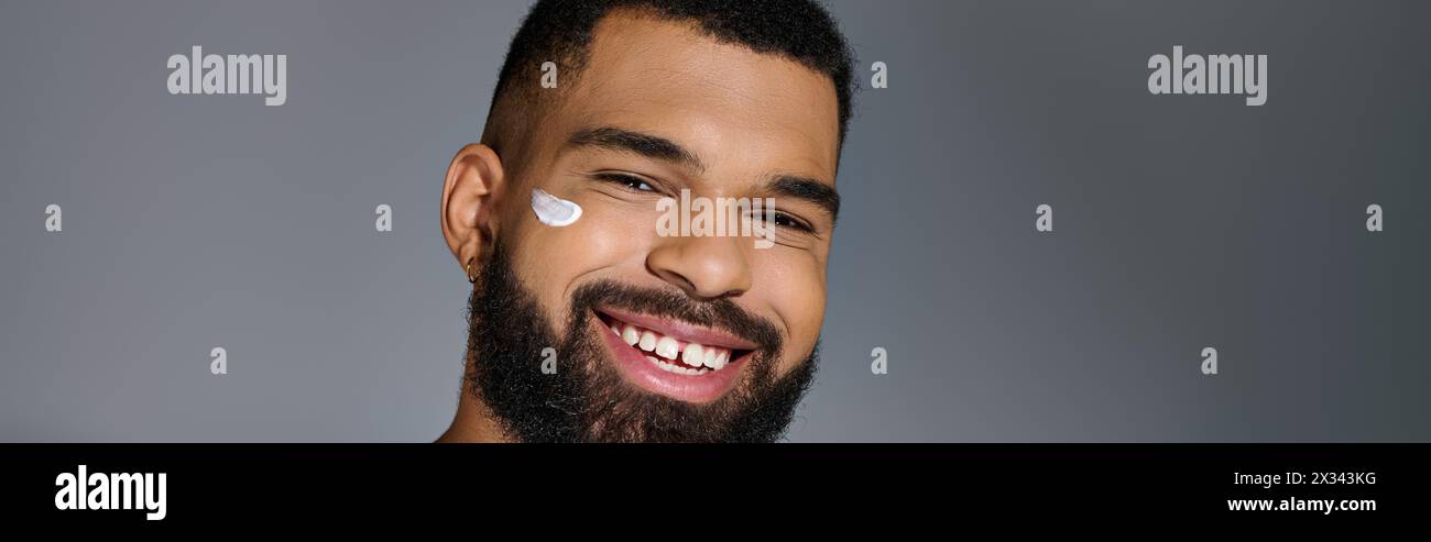 Handsome young man with a beard performing skincare routine. Stock Photo