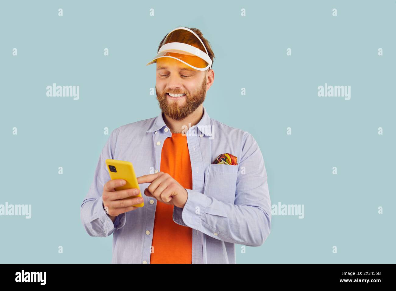 Happy Caucasian Man Using Phone On Blue Background Stock Photo