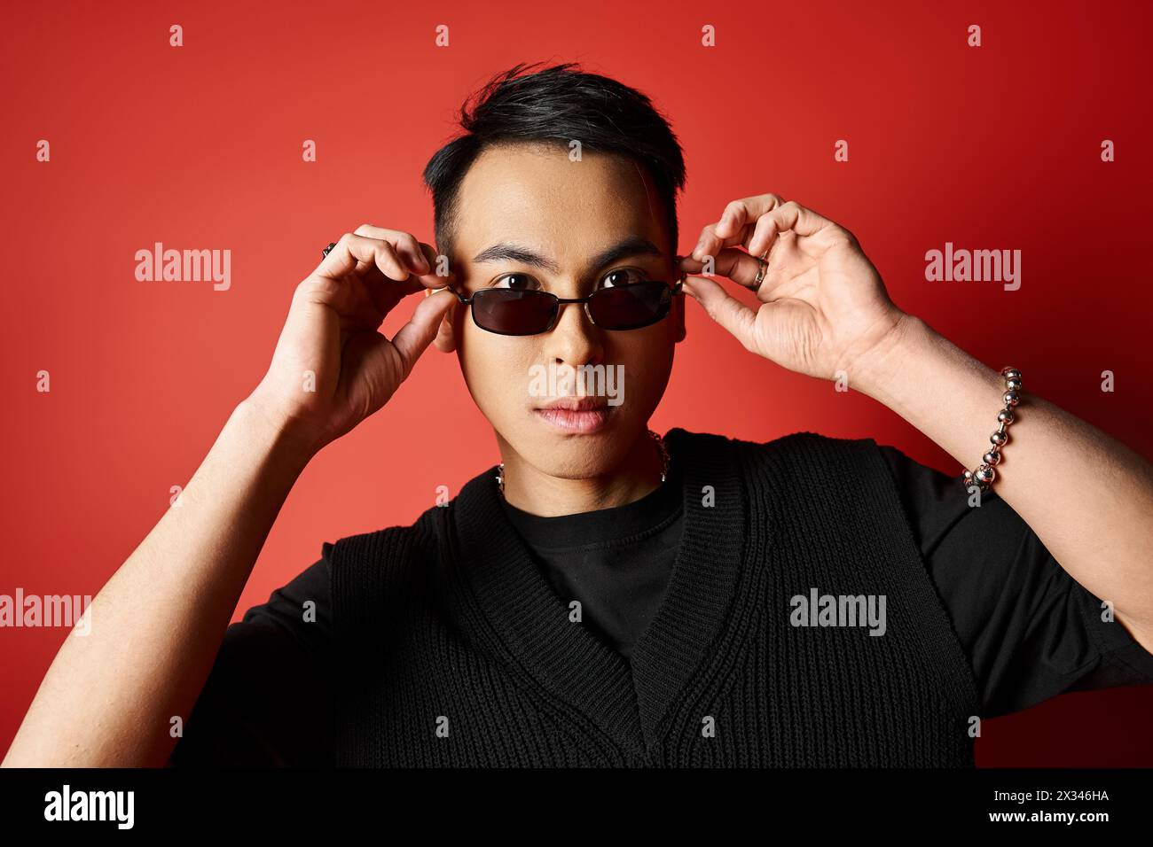 A stylish Asian man in black shirt and sunglasses poses confidently on ...