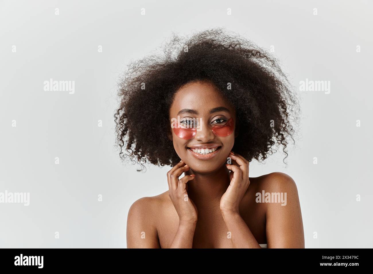 A beautiful young African American woman with curly hair showcases eye ...
