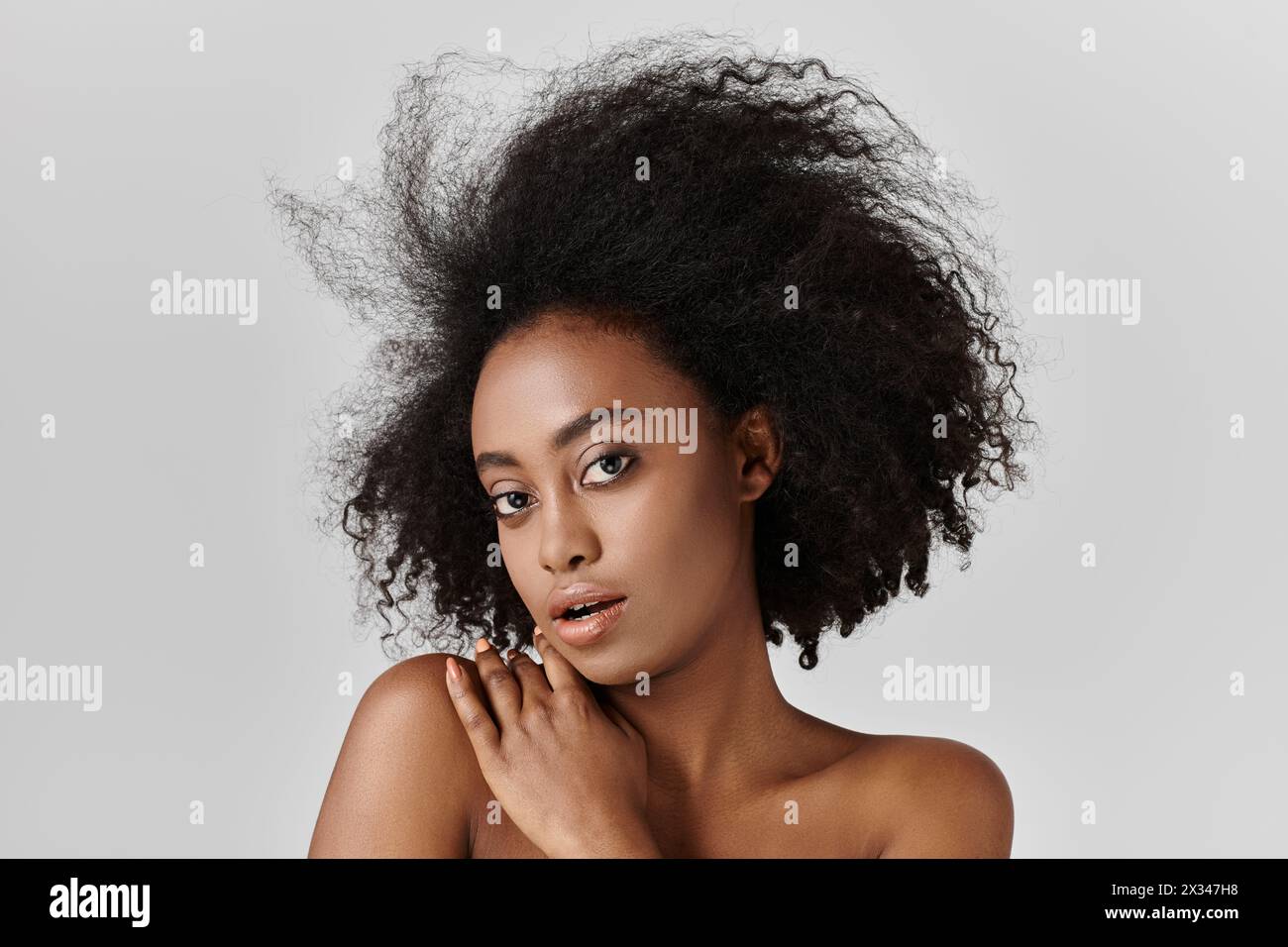 A young African American woman with curly hair posing for a portrait ...