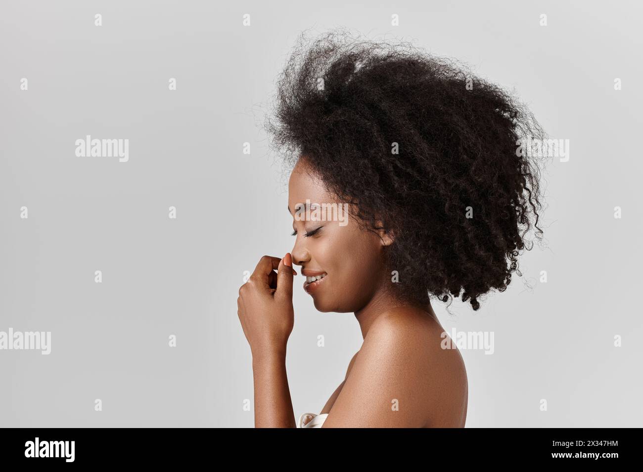 A young African American woman with curly hair poses confidently for a ...