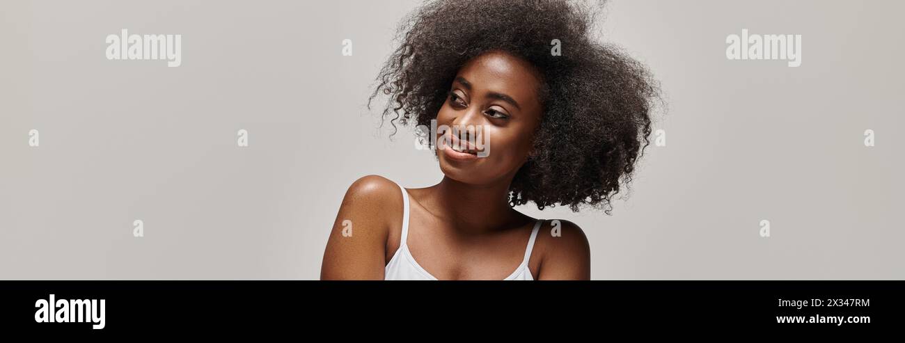 A beautiful young African American woman with curly hair striking a ...