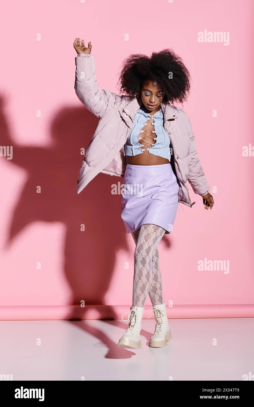 A young African American woman with curly hair stands confidently in ...