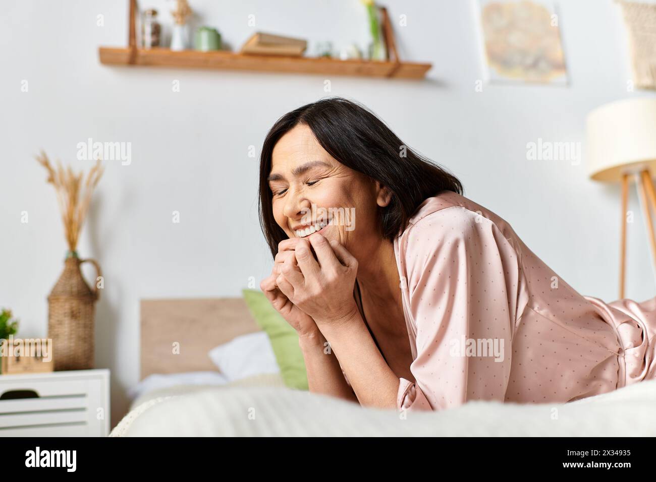 Cozy woman laying on stomach in homewear, embracing relaxation. Stock Photo