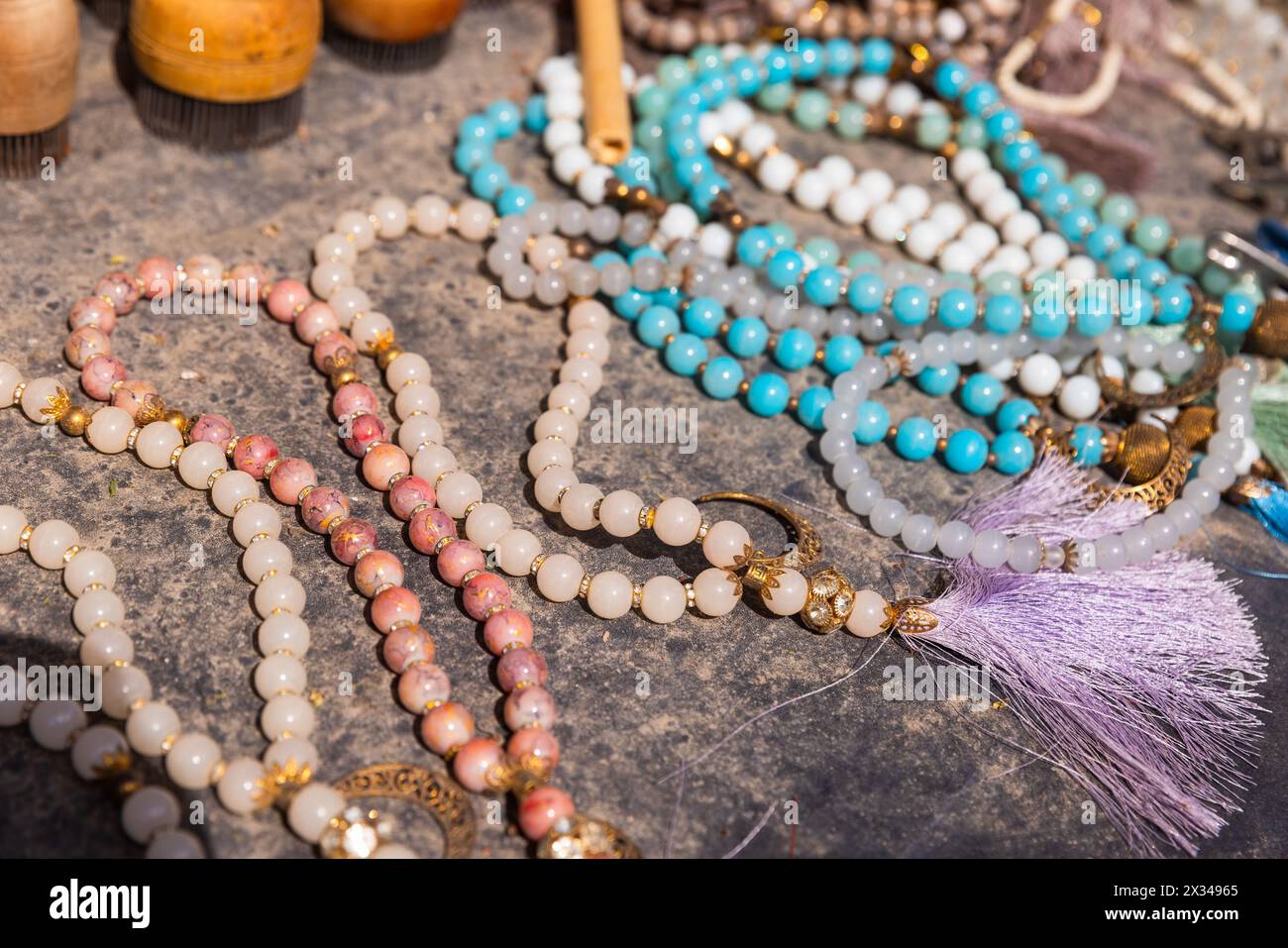 A variety of rosary with gemstone beads lies on the counter of a street market in Bukhara Stock Photo