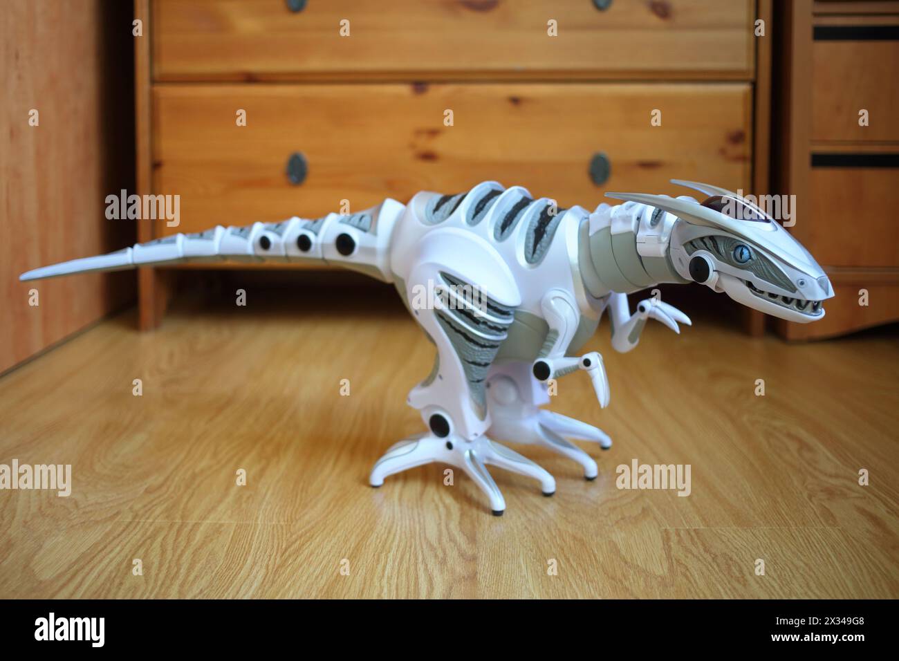 Interactive robot dinosaur standing on the floor in the room Stock Photo