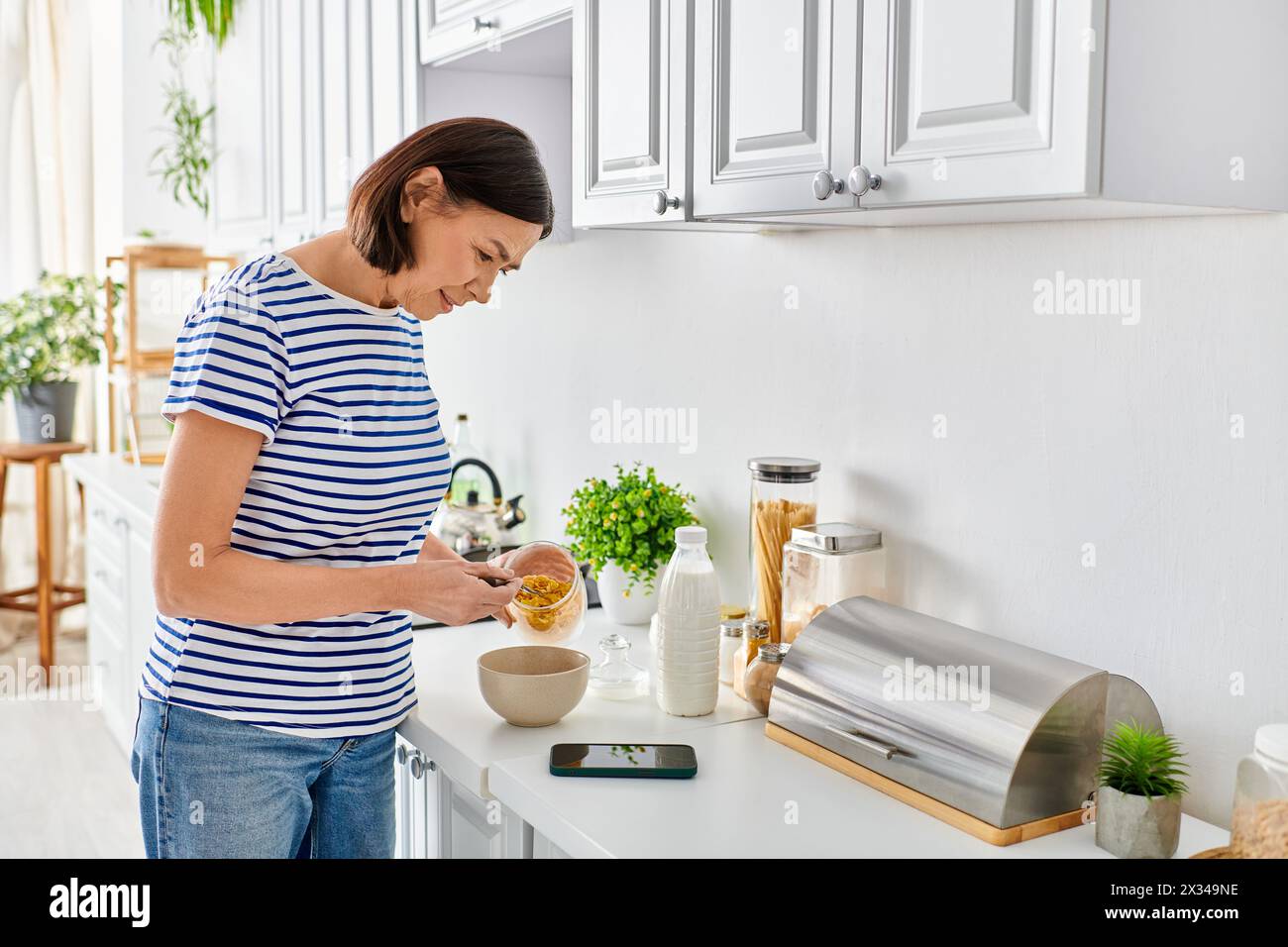A woman in cozy homewear preparing food in a kitchen. Stock Photo