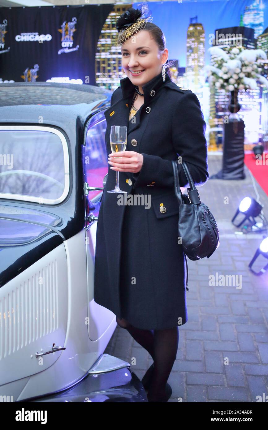 Beautiful woman near retro car at a party in honor of the birthday the glossy magazine in karaoke club Chicago Stock Photo