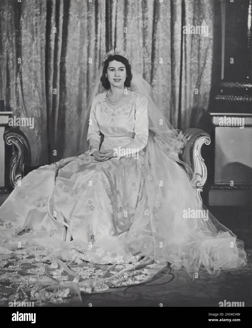 Princess Elizabeth is pictured in her wedding dress on the day she married Philip, the Duke of Edinburgh, on 20th November 1947. The following year, they welcomed their first son, Prince Charles, marking a new generation in the British monarchy. Elizabeth ascended to the throne in 1952, signaling a pivotal shift in royal leadership. Stock Photo