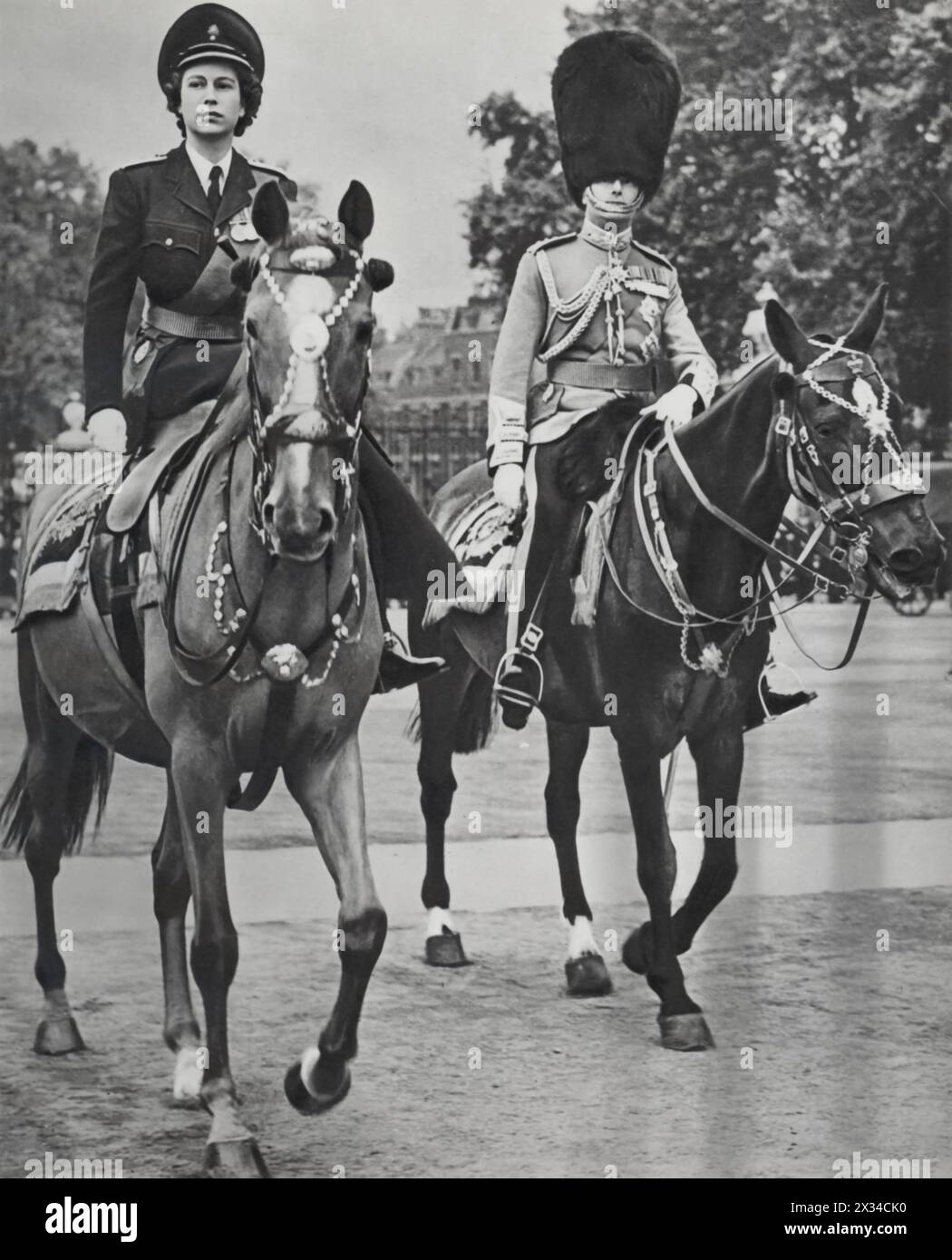 Princess Elizabeth and her uncle, Prince Henry, the Duke of Gloucester, are shown on horseback at the Trooping the Colour ceremony in June 1949. Elizabeth was appointed Colonel-in-Chief of the Grenadier Guards in 1942 at the age of 16, succeeding her great-great uncle. This ceremony, which celebrates the monarch's birthday, highlights the rich traditions of the British monarchy and Elizabeth's early integration into royal duties. Stock Photo