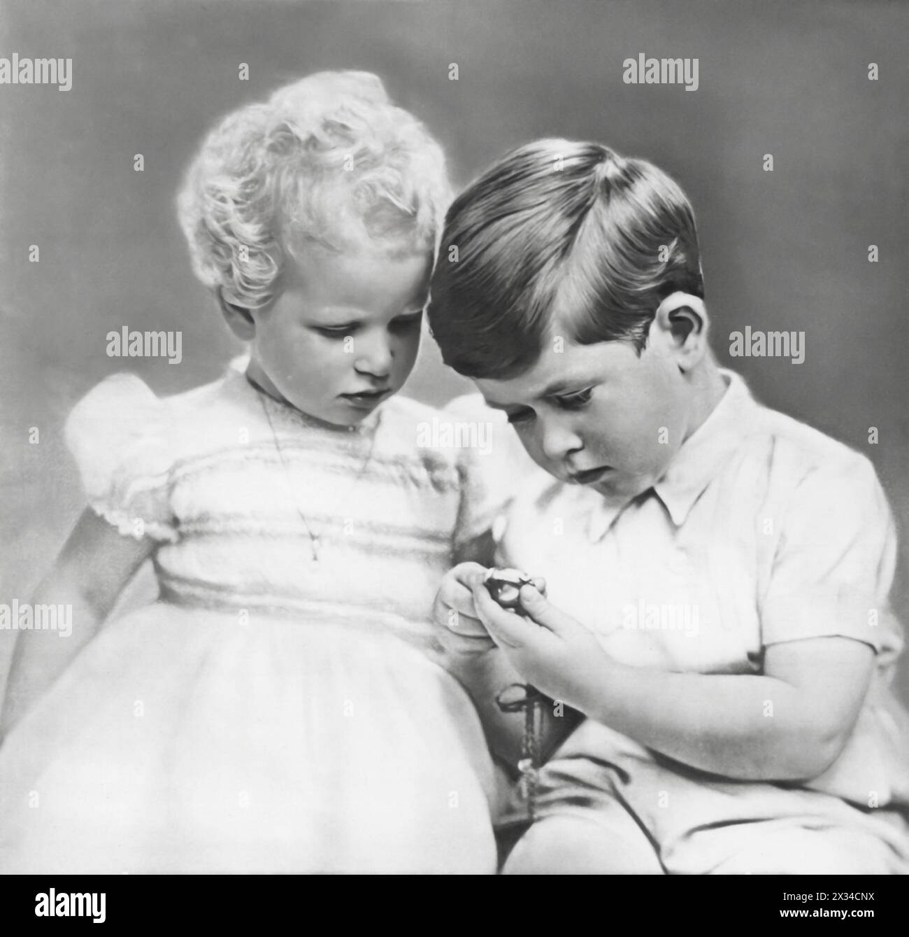 Photograph of a Prince Charles III with his younger sister, Princess Anne, dated circa 1952. This image offers a glimpse into the young royals, prior to their future responsibilties. Stock Photo