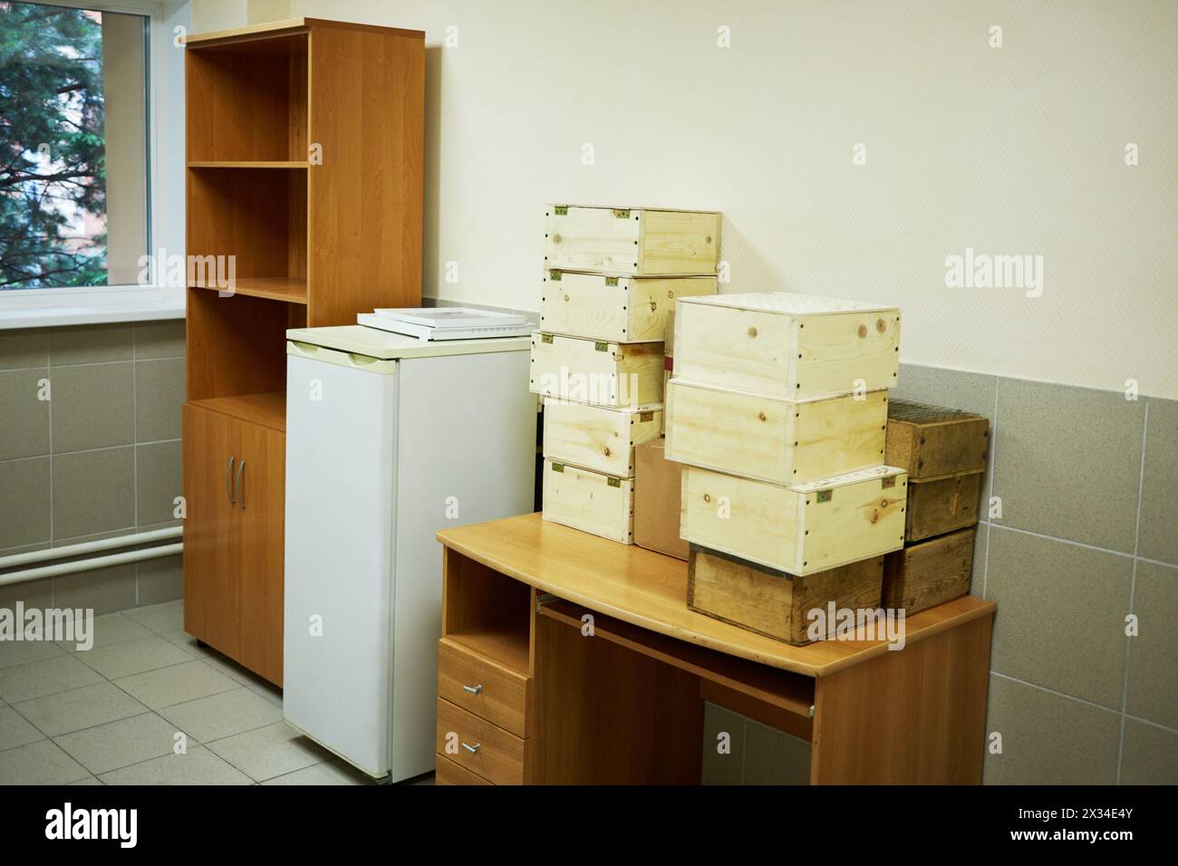 Service room with refrigerator, table, and wooden boxes Stock Photo - Alamy