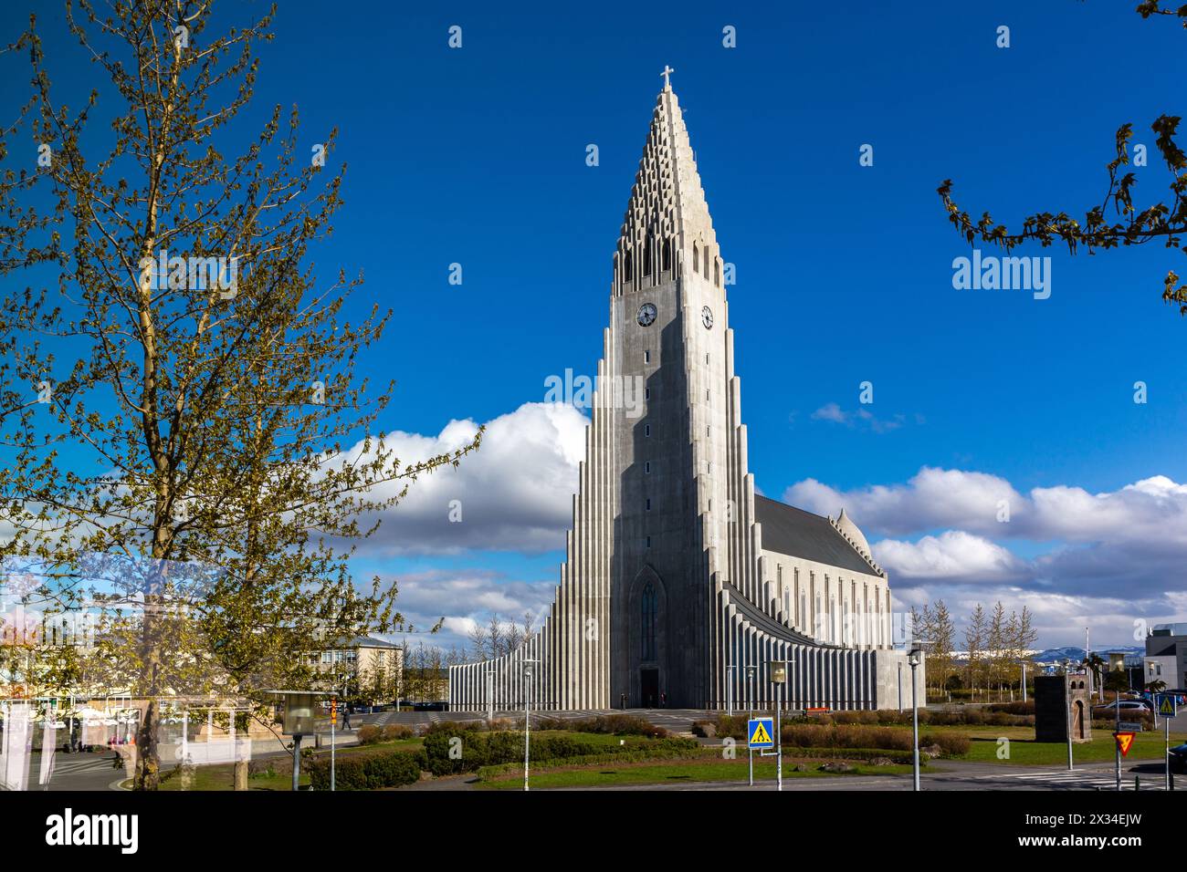 Reykjavik, Iceland, 14.05.22. Hallgrimskirkja modernist church resembling basalt columns in Reykjavik, Iceland on Skolavorduholt hill with trees. Stock Photo