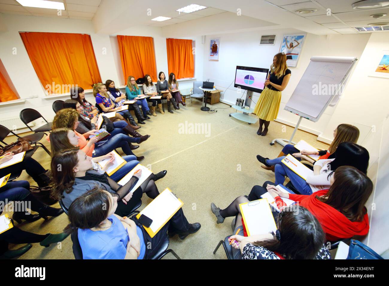 MOSCOW - MAR 26, 2015: Stylist Ekaterina Panyutischeva (with model release) and students at Disclosure of feminine style master class Stock Photo