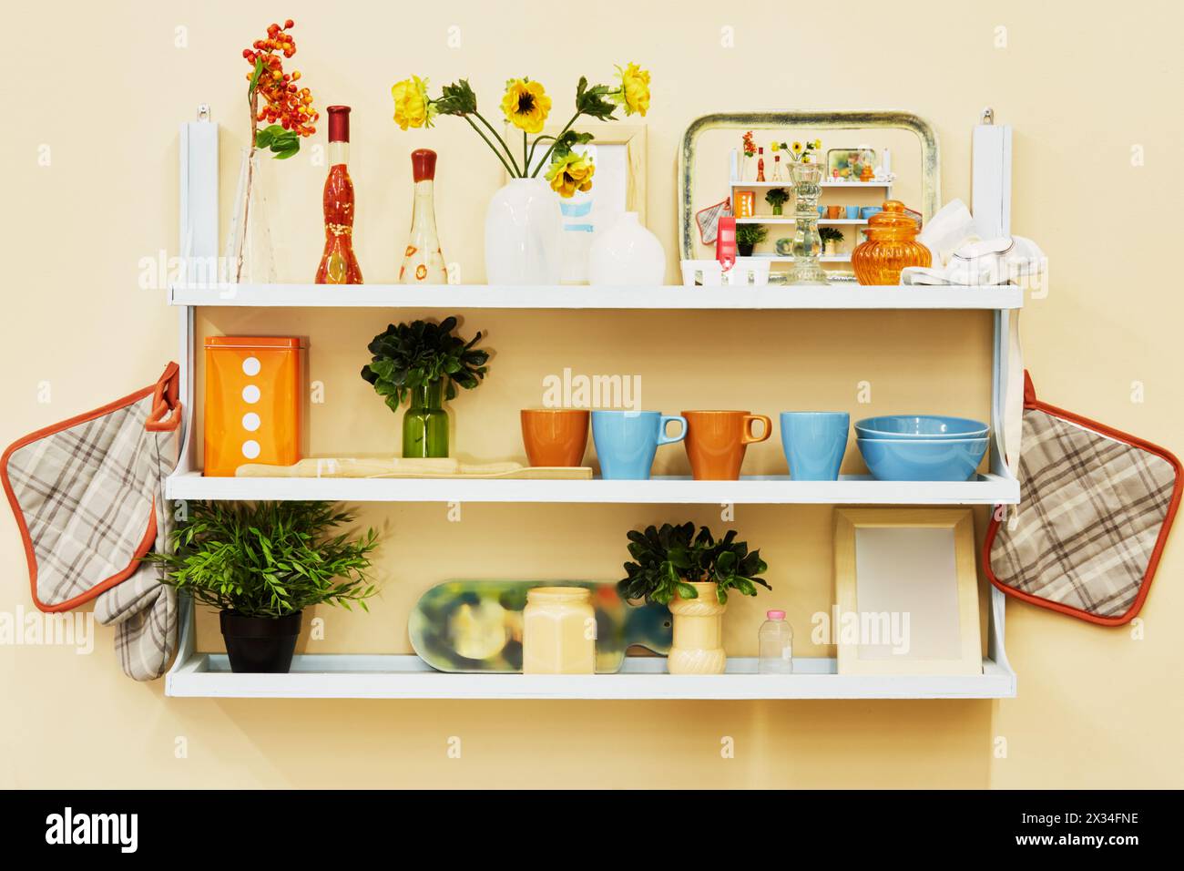 Home-made kitchen shelf with kitchenwear on the wall. Stock Photo
