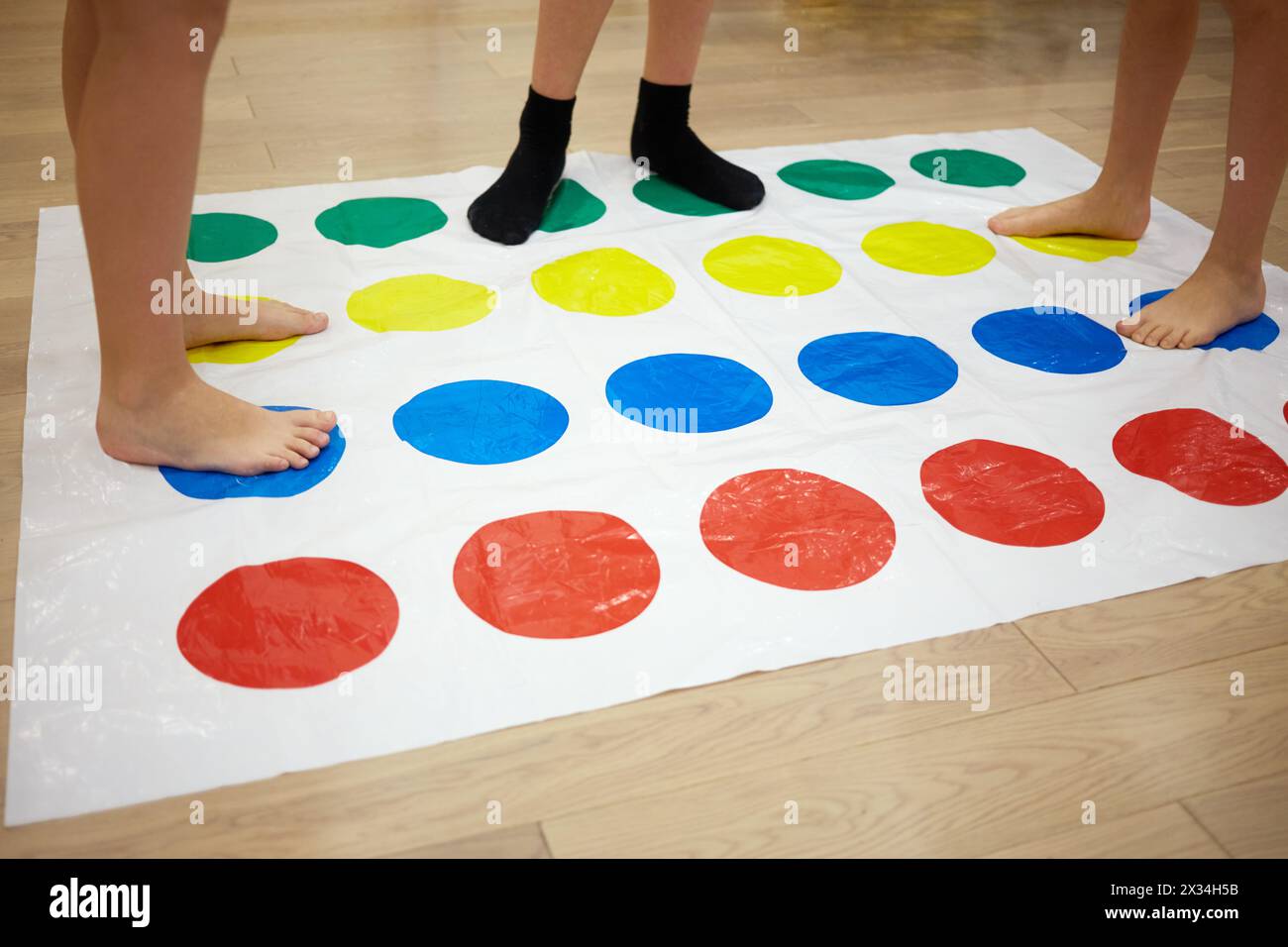 MOSCOW, RUSSIA - MAY 8, 2015: Children play Twister game in room. Twister is a game of physical skill produced by Milton Bradley Company and Winning M Stock Photo