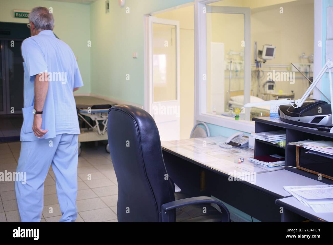The man moves away from the workplace of the nurse near the intensive care unit, view from the back Stock Photo