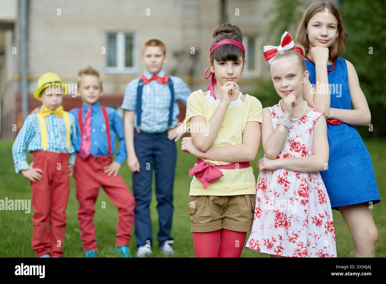Three girls propping chins at foreground and three boys behind them out ...