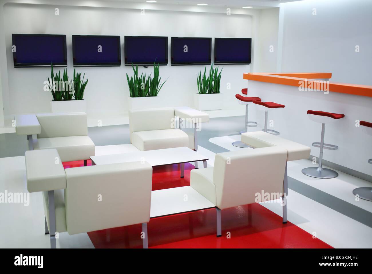 Empty waiting area with white chairs and plasma screens in office Stock Photo