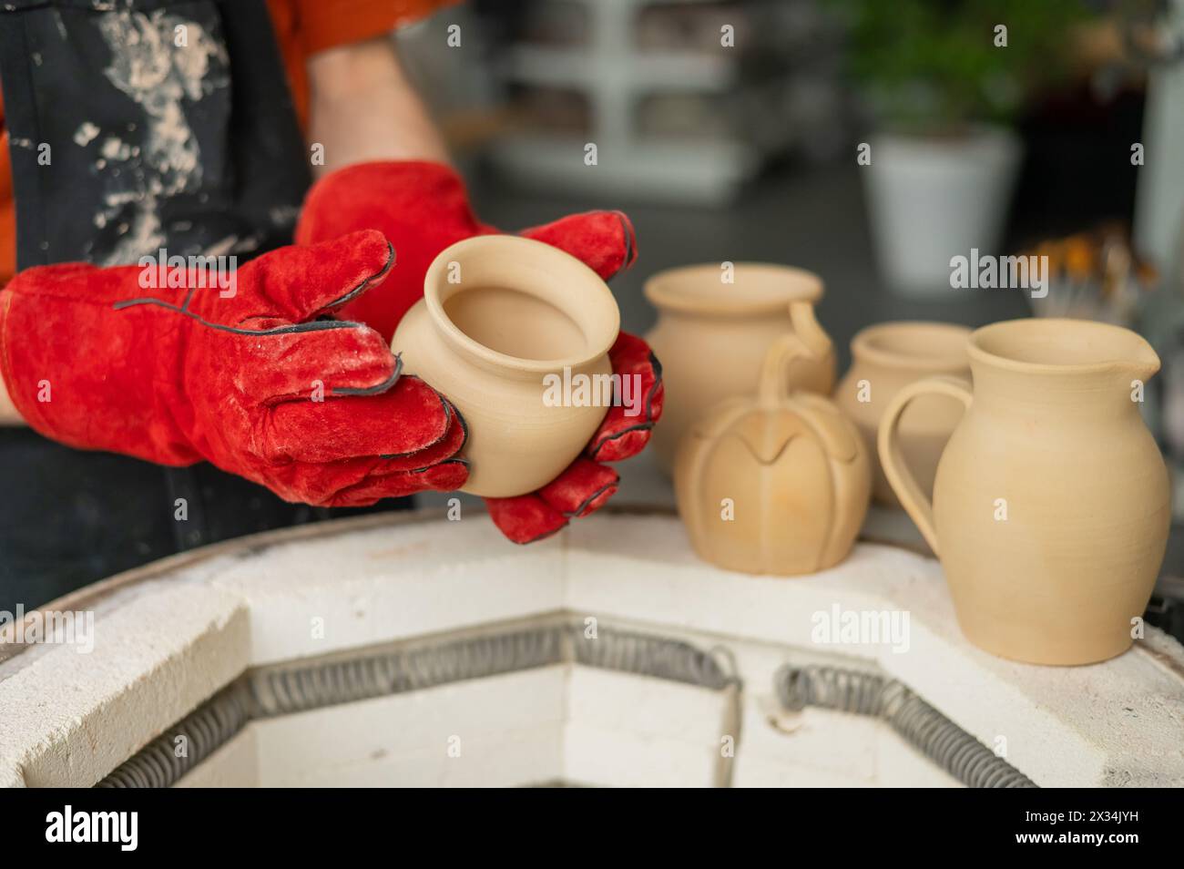 Close-up of a man's hands loading ceramics into a special kiln Stock ...