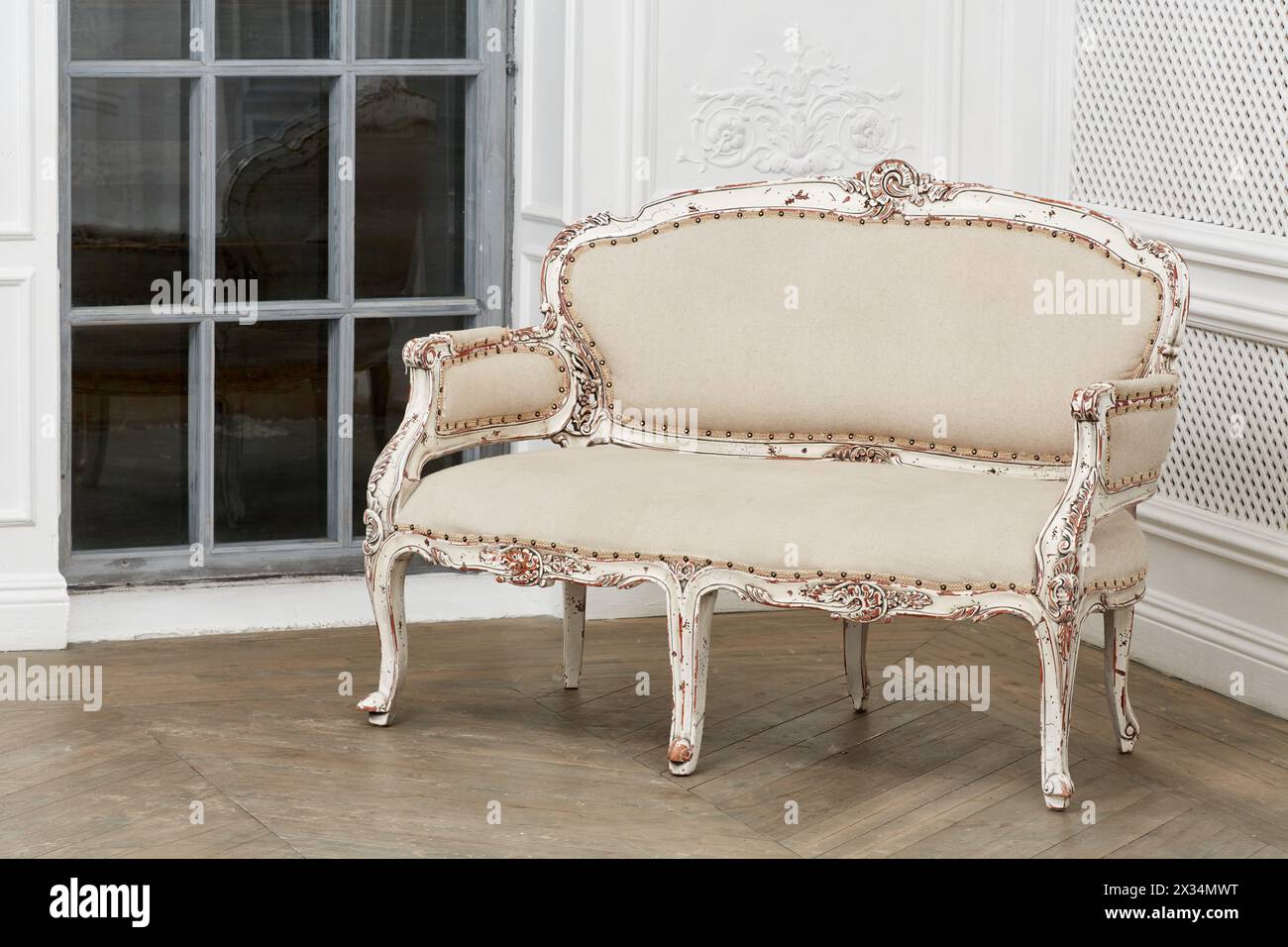 Vintage sofa armchair in room with parquet-flooring and latticed window ...