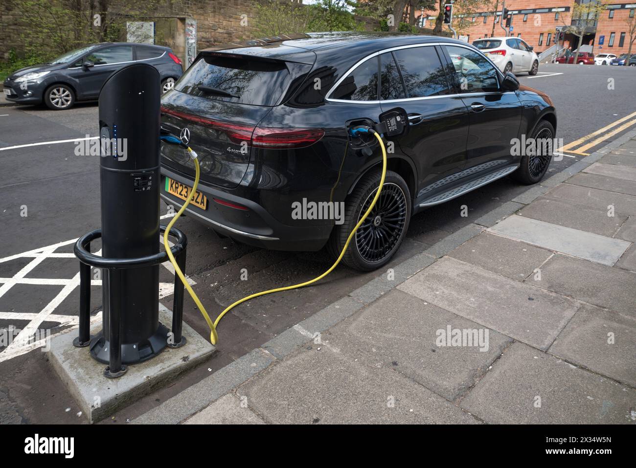 Black electric Mercedes at Electric Vehicle (EV) BP Pulse charging point on an street in Edinburgh, Scotland, UK. Stock Photo