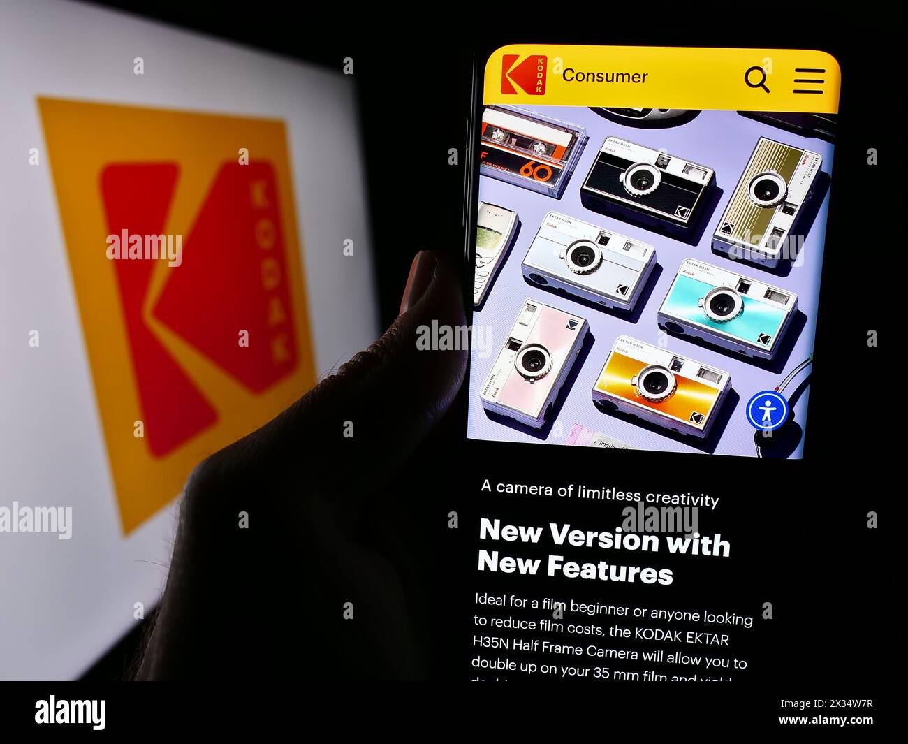 Person holding cellphone with webpage of US electronics business Eastman Kodak Company in front of logo. Focus on center of phone display. Stock Photo