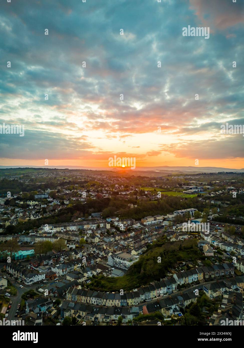 Torquay, UK. 24th Apr, 2024. Sunset over the Devon hills and the town of Torquay. Credit: Thomas Faull/Alamy Live News Stock Photo