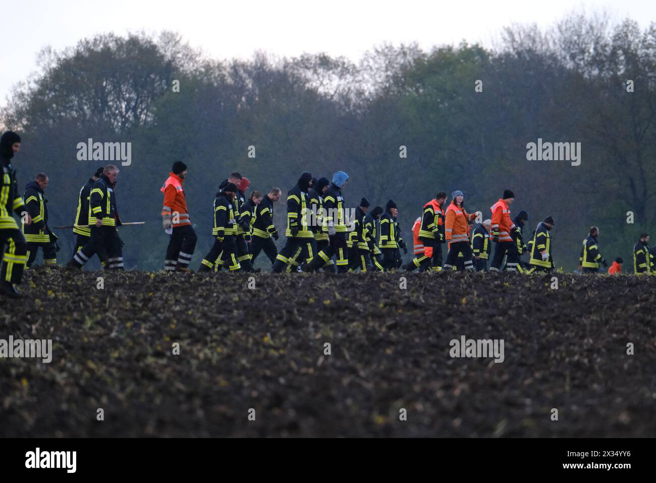 24 April 2024, Lower Saxony, Bremervörde: Firefighters walk across a field near Bremervörde. There is still no trace of a missing six-year-old boy from Bremervörde in Lower Saxony. Photo: Markus Hibbeler/dpa Stock Photo