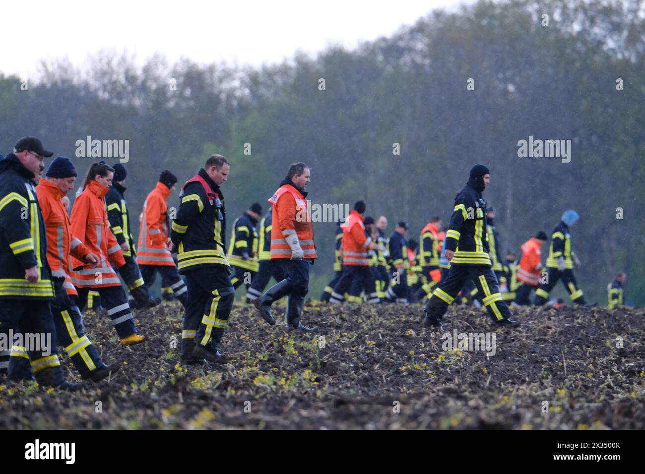 24 April 2024, Lower Saxony, Bremervörde: Firefighters walk across a field near Bremervörde. There is still no trace of a missing six-year-old boy from Bremervörde in Lower Saxony. Photo: Markus Hibbeler/dpa Stock Photo